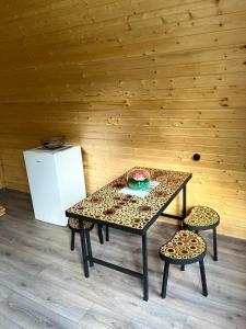 a table and two chairs in a room with a refrigerator at Gudika • გუდიკა in Sno