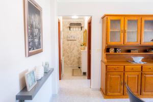 uma cozinha com um armário de madeira e um corredor em El balcón de Barraña em Boiro
