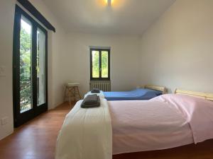 a bedroom with a bed in a room with windows at Casa Bellavista - Serena in Lugano