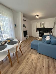 uma sala de estar com um sofá azul e uma mesa em Azzurro Premium Apartment on Bulevard Bogoridi em Burgas