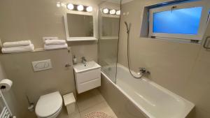 a bathroom with a toilet and a tub and a sink at Diamond House in Veresegyház