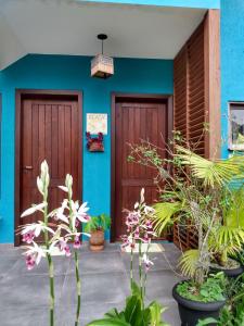 dos puertas de una casa con plantas y flores en Pousada Vila Guyrá, en Florianópolis