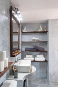 馬蘇里的住宿－Menori Luxury Suites-Villa Athina，浴室配有盥洗盆、镜子和毛巾