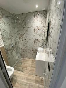 La salle de bains est pourvue d'une douche, de toilettes et d'un lavabo. dans l'établissement EQ Tirana Apartments, à Tirana
