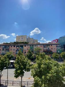 un groupe d'arbres devant un bâtiment dans l'établissement EQ Tirana Apartments, à Tirana