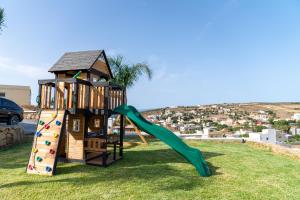 un parque infantil con tobogán y estructura de juegos en CASA DEL TITO en Oulad Akkou