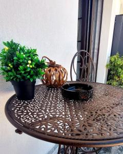une table avec deux plantes en pot sur un balcon dans l'établissement Nina Apartment, à Dráma