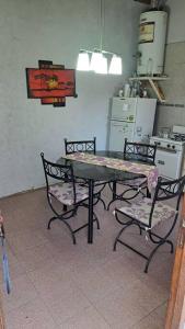 una cocina con mesa, 2 sillas y mesa y una cocina con en Simple y cálido departamento en Maipú