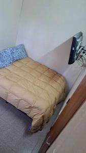 Simple y cálido departamento في مايبو: وجود سرير في زاوية الغرفة