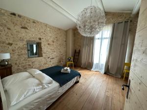 um quarto com uma cama e um lustre em Mas Saint-Ferdinand - maison avec piscine em La Capelle-et-Masmolène