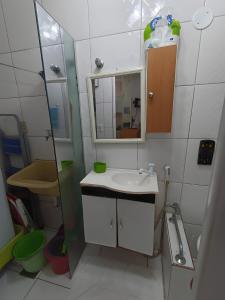 Baño pequeño con lavabo y espejo en Apartamento Meia Cinco, en Santos