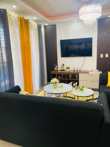 sala de estar con 2 mesas y sofá en Confortable y lujoso apartamento en santiago, en Santiago de los Caballeros