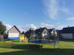 a playground with a trampoline in the grass at NADMORSKI RESORT in Niechorze