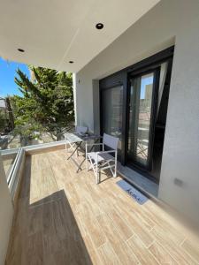 Un patio con una mesa y sillas en un balcón. en C&C3 Apartments, en Alexandroupoli