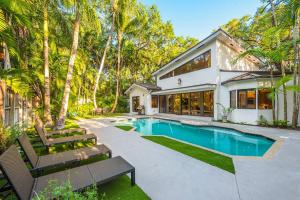 an exterior view of a house with a swimming pool at Coconut Grove Villa with heated Pool sleeps 12 in Miami