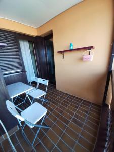 einen Balkon mit Stühlen, einem Tisch und einem Regal in der Unterkunft Apartman Sofka in Vranje