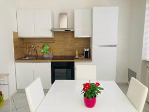 une cuisine avec une table blanche et un vase rouge. dans l'établissement La casa di Giulio, à Ronciglione