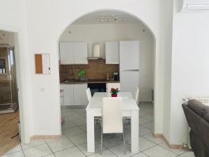 - une salle à manger blanche avec une table et des chaises blanches dans l'établissement La casa di Giulio, à Ronciglione