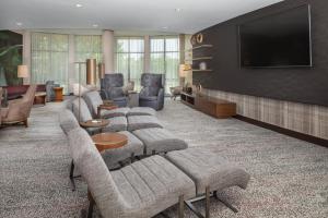 a living room with couches and a flat screen tv at Courtyard by Marriott Anniston Oxford in Oxford