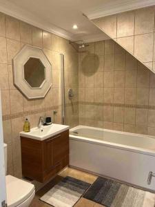 a bathroom with a sink and a tub and a toilet at Bright and Cosy Home in Southend-on-Sea