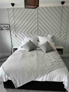 a bedroom with a large bed with white sheets and pillows at Bright and Cosy Home in Southend-on-Sea