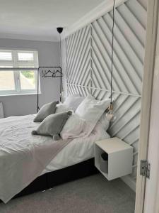 a bedroom with a large bed with a black and white headboard at Bright and Cosy Home in Southend-on-Sea