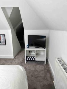 a bedroom with a bed and a tv in a room at Bright and Cosy Home in Southend-on-Sea