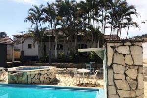 a house with a swimming pool and palm trees at Casa de campo com piscina, mesa de bilhar e 3 quartos in Itanhandu