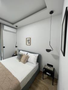 Un dormitorio blanco con una cama y una mesa. en C&C3 Apartments, en Alexandroupoli