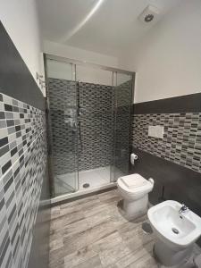 a bathroom with a shower and a toilet and a sink at Kalasó Design Guest House - Rome Airport in Fiumicino +9 photos