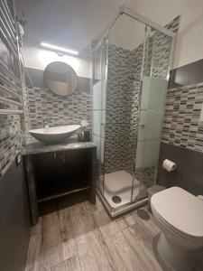 a bathroom with a shower and a sink and a toilet at Kalasó Design Guest House in Fiumicino