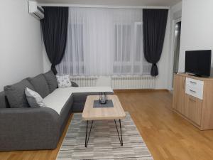 sala de estar con sofá y mesa de centro en Apartman VIAGGIO en Sremska Mitrovica
