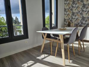 una sala da pranzo con tavolo e sedie bianchi di 1B105 Bonito apartamento en zona exclusiva a Gijón