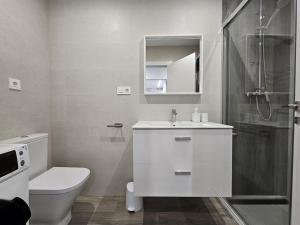 a bathroom with a toilet and a sink and a shower at 1B105 Bonito apartamento en zona exclusiva in Gijón