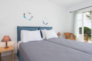 ein Schlafzimmer mit einem Bett mit weißen Kissen und einem Fenster in der Unterkunft Apelagitis 2 in Katavatí