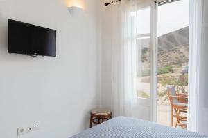 a bedroom with a bed and a television on a wall at Apelagitis 1 in Exámbela