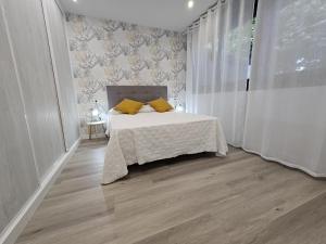 een slaapkamer met een bed met gele kussens erop bij 1A105 Precioso apartamento en zona exclusiva in Gijón