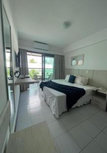 1 dormitorio con 1 cama grande y escritorio. en Araça Praia Flat - Ap 507 - Vista Mar, en Natal