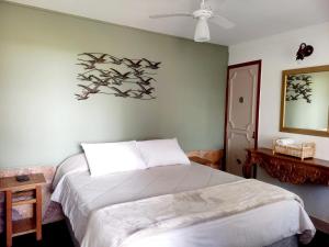 una camera con letto e ventilatore a soffitto di Pousada Casa Direita a Tiradentes