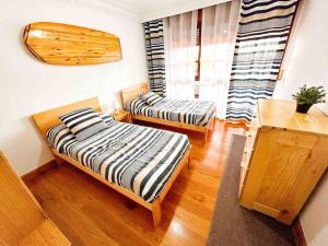 a room with two beds and a table and a window at La Casa de Enzo in Argoños