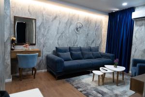 - un salon avec un canapé bleu et une table dans l'établissement Holiday apartaments, à Tirana