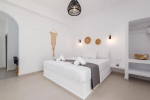 a white bedroom with a white bed in a room at ALTHEA PAROS in Naousa