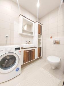 a white bathroom with a washing machine and a toilet at Kraków centrum in Krakow