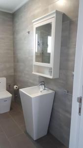 a bathroom with a sink and a toilet and a mirror at Villa con vistas al mar y piscina privada Oued Aliane in Mrarech