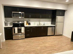 a kitchen with black cabinets and stainless steel appliances at Studios Universal 10 min drive FREE parking and WIFI in Los Angeles