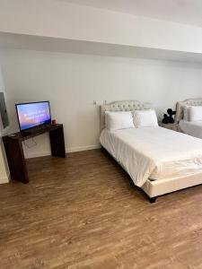 Schlafzimmer mit einem Bett und einem Flachbild-TV in der Unterkunft Studios Universal 10 min drive FREE parking and WIFI in Los Angeles