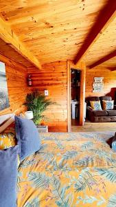 1 dormitorio con 1 cama en una cabaña de madera en Morlais Log Cabin, en Lyme Regis