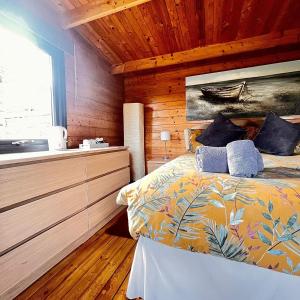 a bedroom with a bed and a wooden wall at Morlais Log Cabin in Lyme Regis