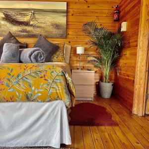 a bedroom with a bed and a potted plant at Morlais Log Cabin in Lyme Regis