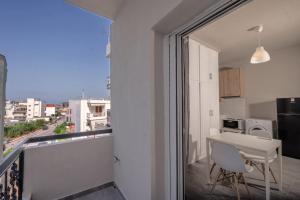 a room with a balcony with a table and a kitchen at Casa Bona in Preveza